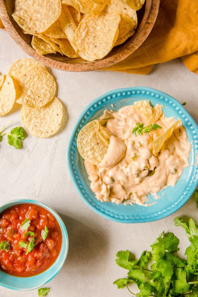 Tortilla chips in a bowl of nacho cheese sauce 