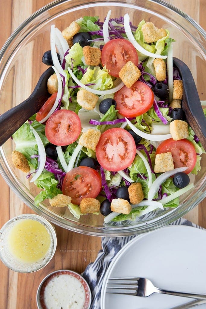 Olive Garden salad served in a white bowl with dressing on the side