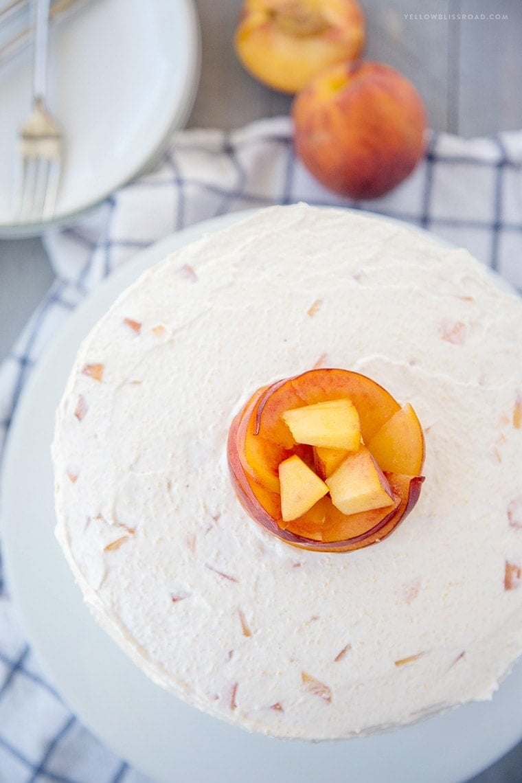 Vanilla Peach Layer Cake is a perfect dessert for summer. Tender, moist cake is layered with a sweet peaches and cream frosting, with chunks of fresh peaches.