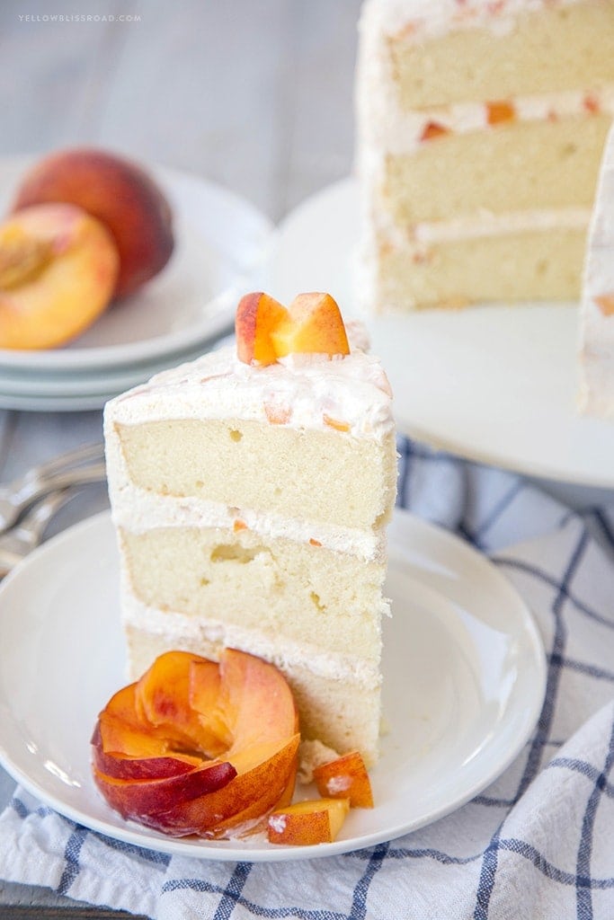 Vanilla Peach Layer Cake is a perfect dessert for summer. Tender, moist cake is layered with a sweet peaches and cream frosting, with chunks of fresh peaches.