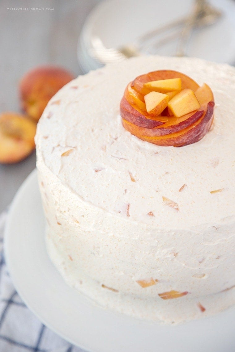 Vanilla Peach Layer Cake is a perfect dessert for summer. Tender, moist cake is layered with a sweet peaches and cream frosting, with chunks of fresh peaches.