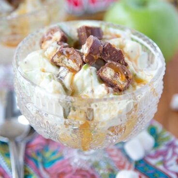 A close up of Twix and Apples in a bowl