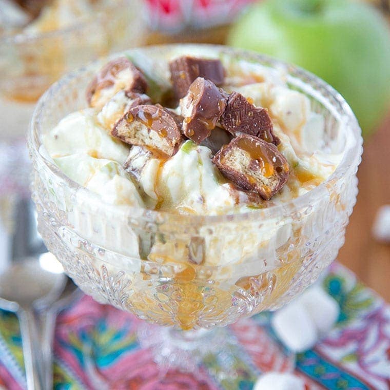 A close up of Twix and Apples in a bowl