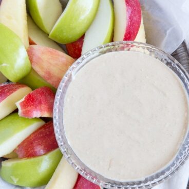 A bowl of dip with apples
