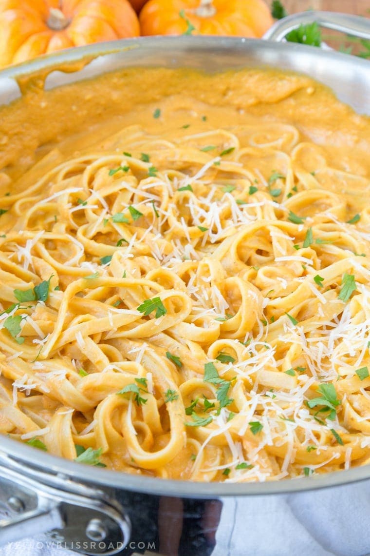 Creamy Pumpkin Alfredo - A perfect dinner that's easy enough for a weeknight meal and you'll never miss the cream! Pumpkin recipes are a must for fall! Side view of a pan of fettuccine with pumpkin alfredo sauce
