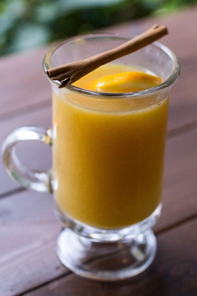 A glass of orange spice hot apple cider in a glass