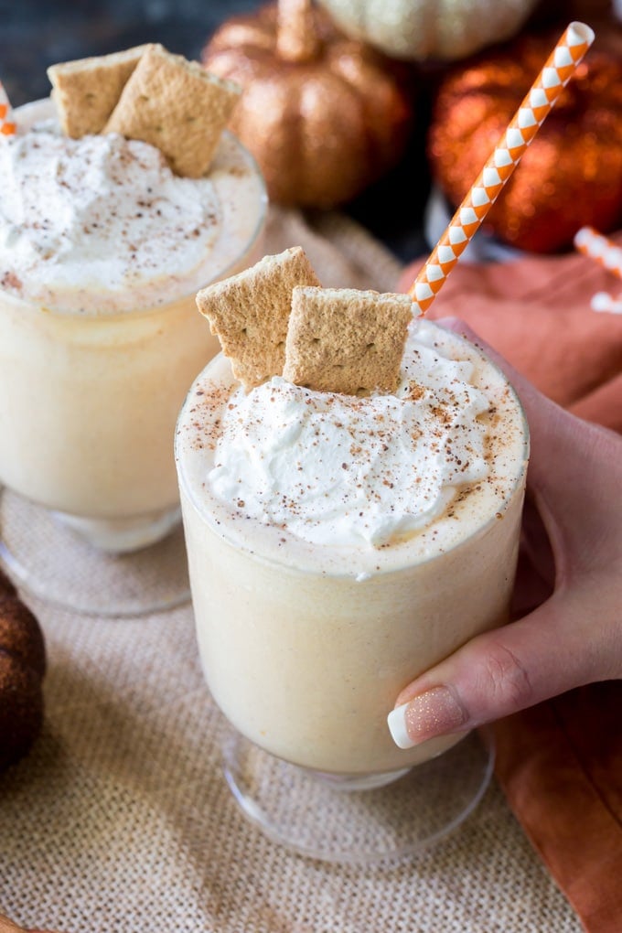 Two glasses filled with pumpkin pie milkshakes