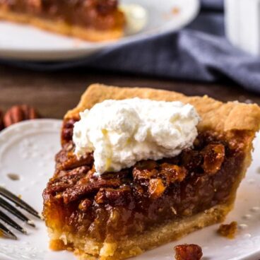 A piece of Pecan pie with whipped cream