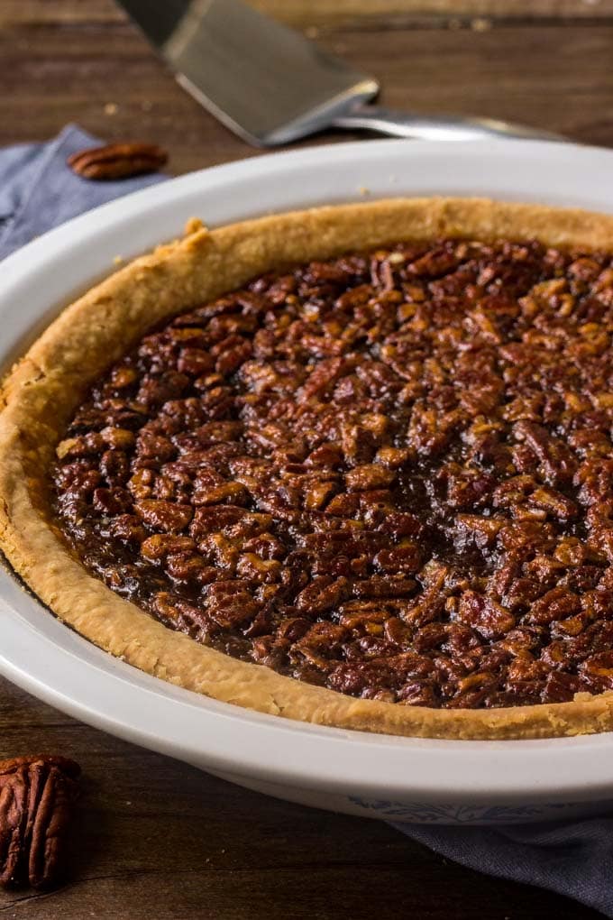 A whole pecan pie in a white pie plate.