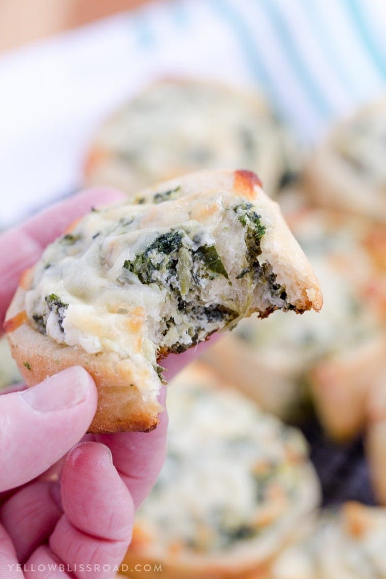 Spinach Artichoke Dip Pinwheel Appetizer with a bit taken out of it.