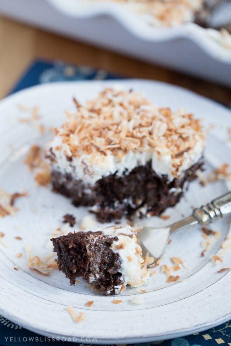 Chocolate Coconut Cream Poke Cake - Rich chocolate cake, coconut cream filling and fluffy, creamy frosting. A rich and decadent dessert!