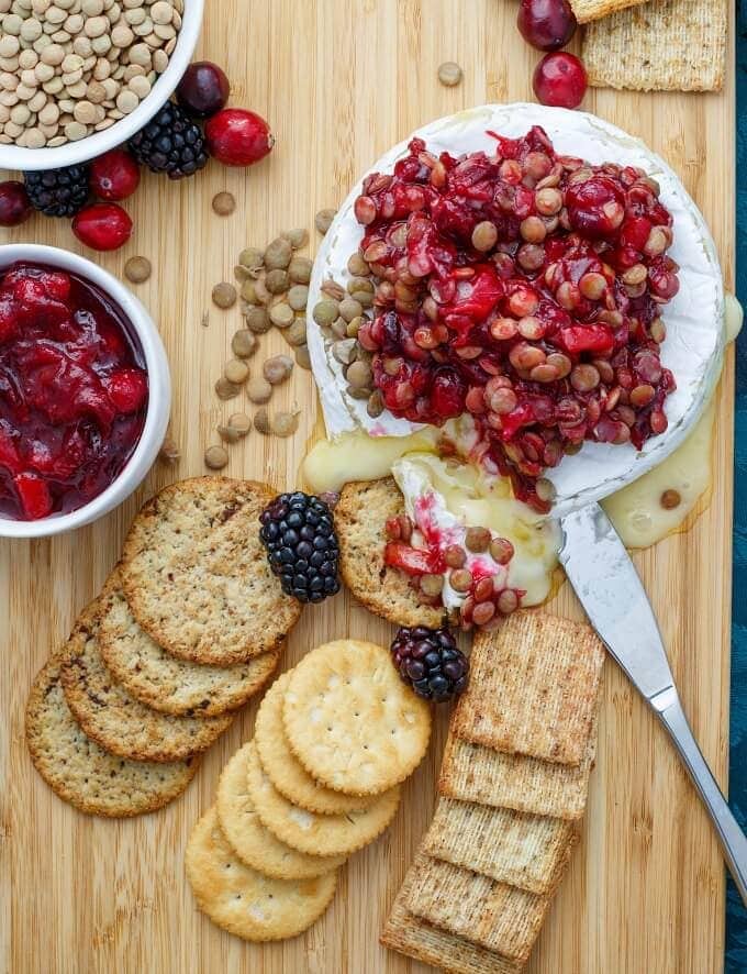 A wooden table topped with Crackers and Brie