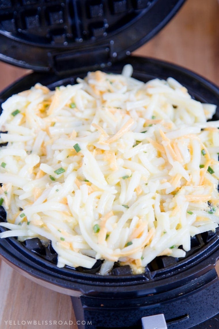 Hashbrowns with eggs and cheese in a waffle maker.