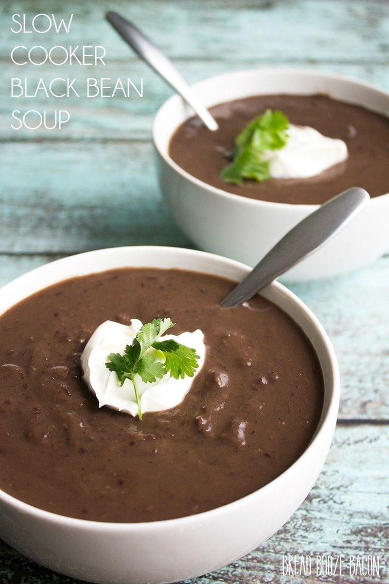 Two bowls of black bean soup on a table