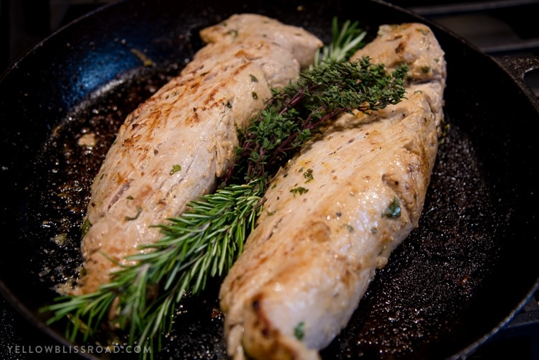 Two cooked pork tenderloins in a pan