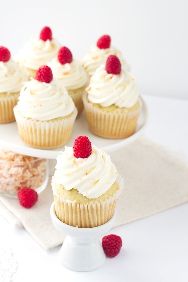 Coconut Cupcakes with a Raspberry Filling - coconut flavored cupcakes filled with a fresh raspberry filling and topped with a delicious coconut frosting and toasted coconut.