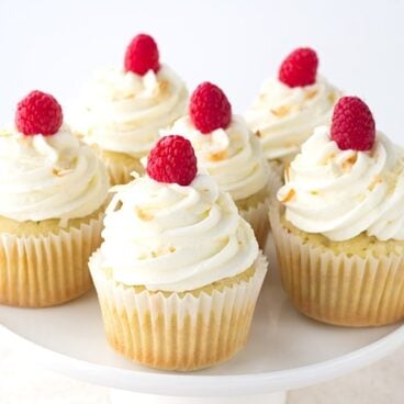 Coconut Cupcakes with a Raspberry Filling - coconut flavored cupcakes filled with a fresh raspberry filling and topped with a delicious coconut frosting and toasted coconut.