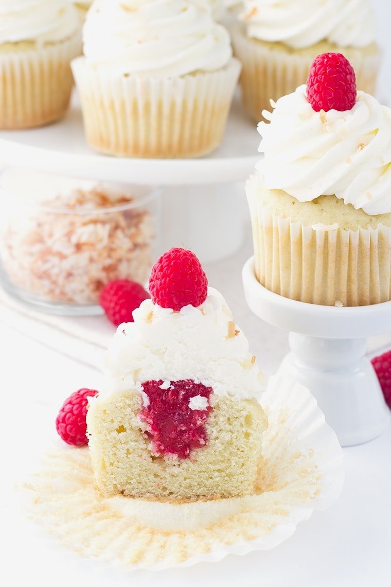 Coconut Cupcakes with a Raspberry Filling - coconut flavored cupcakes filled with a fresh raspberry filling and topped with a delicious coconut frosting and toasted coconut.