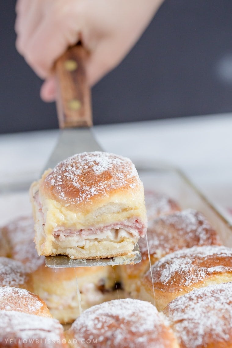 Monte Cristo Sandwich Sliders are the classic sandwich, in "mini" form. Perfect for parties, or just when you want something delicious and a little different and fun. Monte cristo sandwich slider raised from the pan on a spatula.