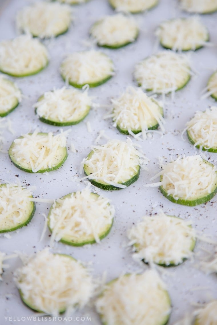 Baked Parmesan Zucchini Crisps are a highly addictive snack that is simple to make with just two ingredients! You'll love these healthy zucchini chips! Sliced zucchini with shredded parmesan cheese