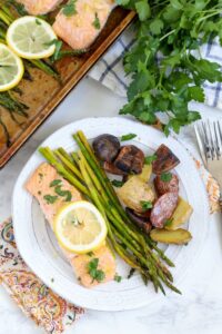 A plate of salmon, potatoes and asparagus on a table