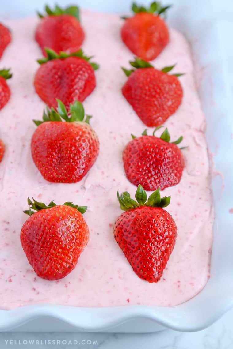 This Strawberries and Cream Poke Cake takes full advantage of Strawberry season with tons of fresh strawberries in the filling and the frosting. It's a strawberry lovers dream dessert!