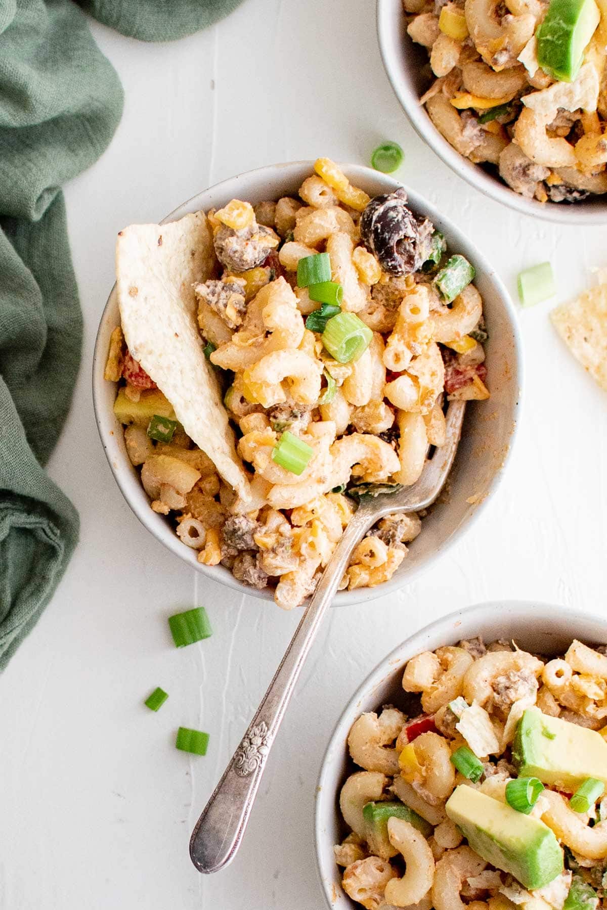 Taco pasta salad with corn and tortilla chips in a bowl.