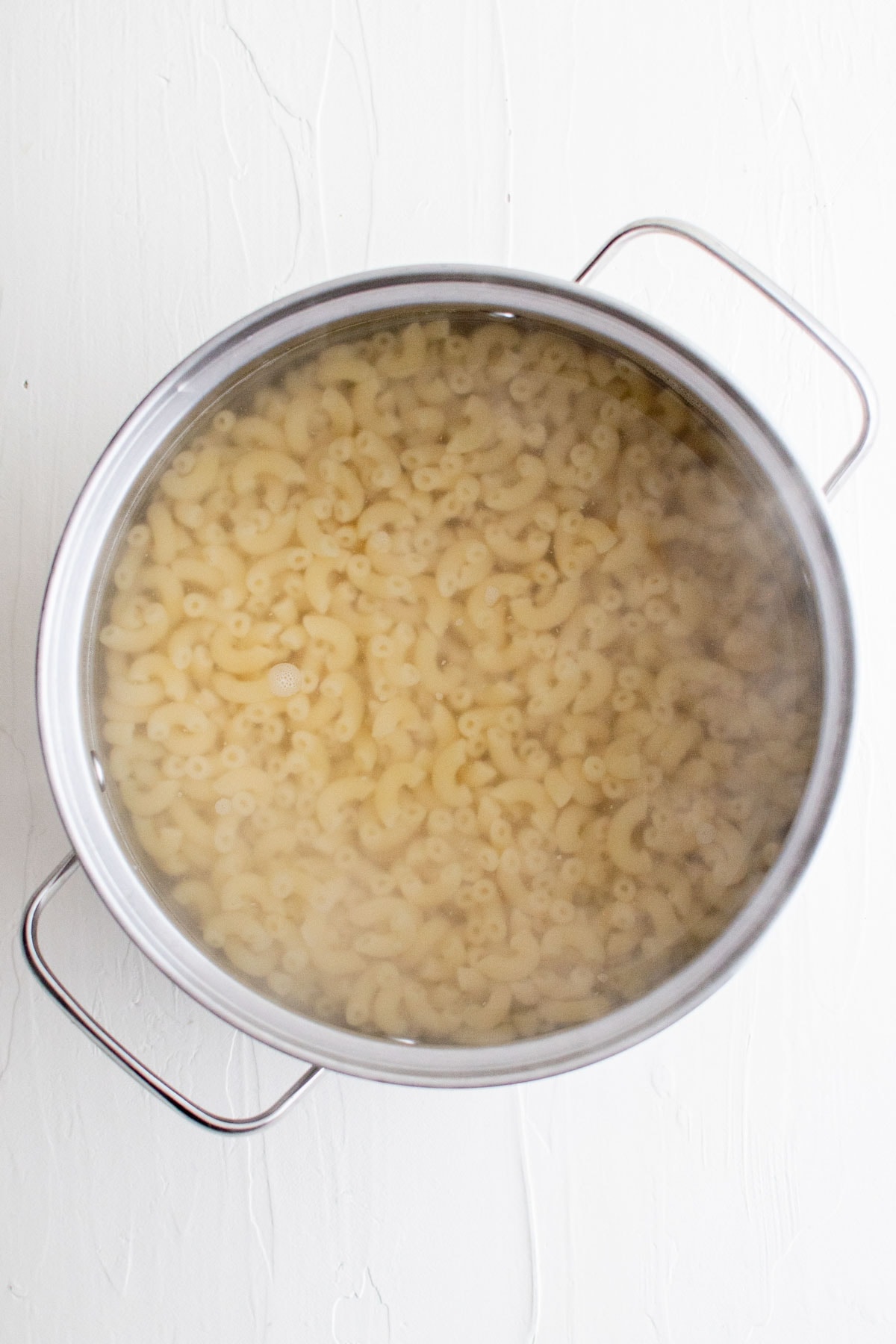 Macaroni is boiling water in a pot.