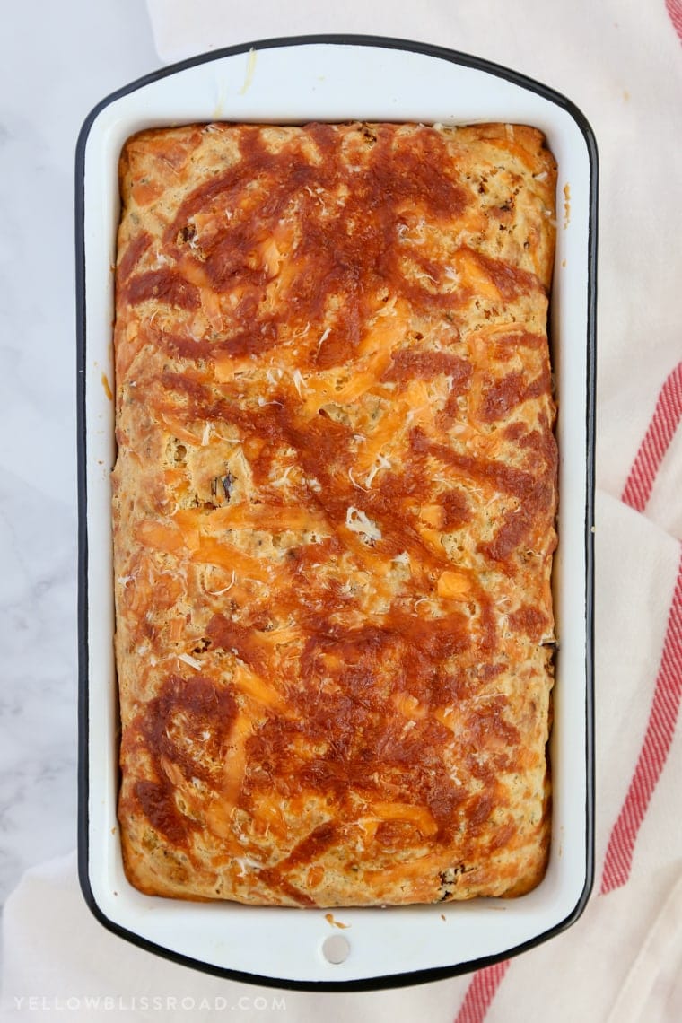 This Cheesy Pizza Bread is a savory quick bread recipe full of sun-dried tomatoes and three kinds of cheese! Great as a snack or with your favorite plate of spaghetti!