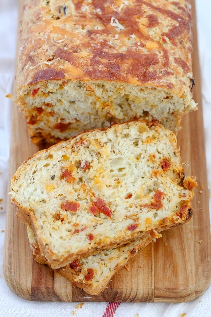 This Cheesy Pizza Bread is a savory quick bread recipe full of sun-dried tomatoes and three kinds of cheese! Great as a snack or with your favorite plate of spaghetti!