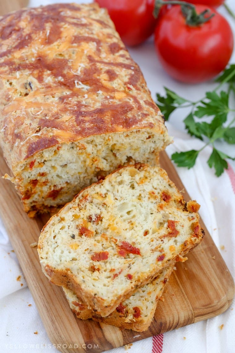 This Cheesy Pizza Bread is a savory quick bread recipe full of sun-dried tomatoes and three kinds of cheese! Great as a snack or with your favorite plate of spaghetti!