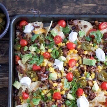 Sheet Pan Nachos are loaded with toppings and are sure to be a great crowd-pleaser!