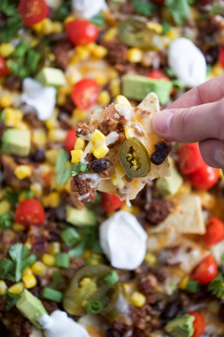 Sheet Pan Nachos are loaded with toppings and are sure to be a great crowd-pleaser - perfect for Cinco de Mayo! 