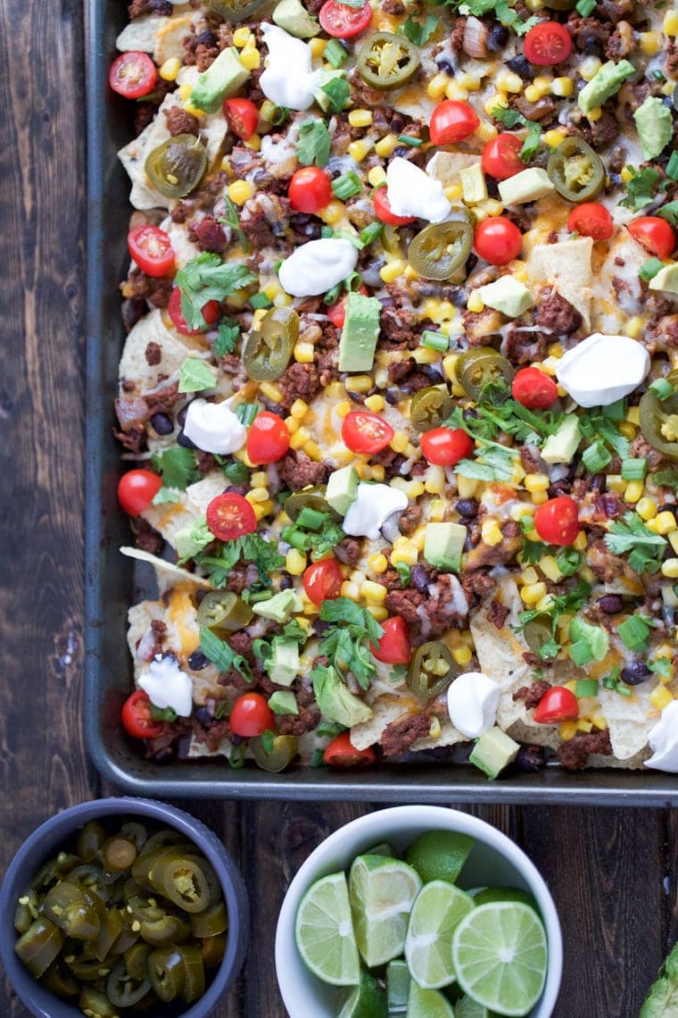 Sheet Pan Nachos are loaded with toppings and are sure to be a great crowd-pleaser - perfect for Cinco de Mayo! 