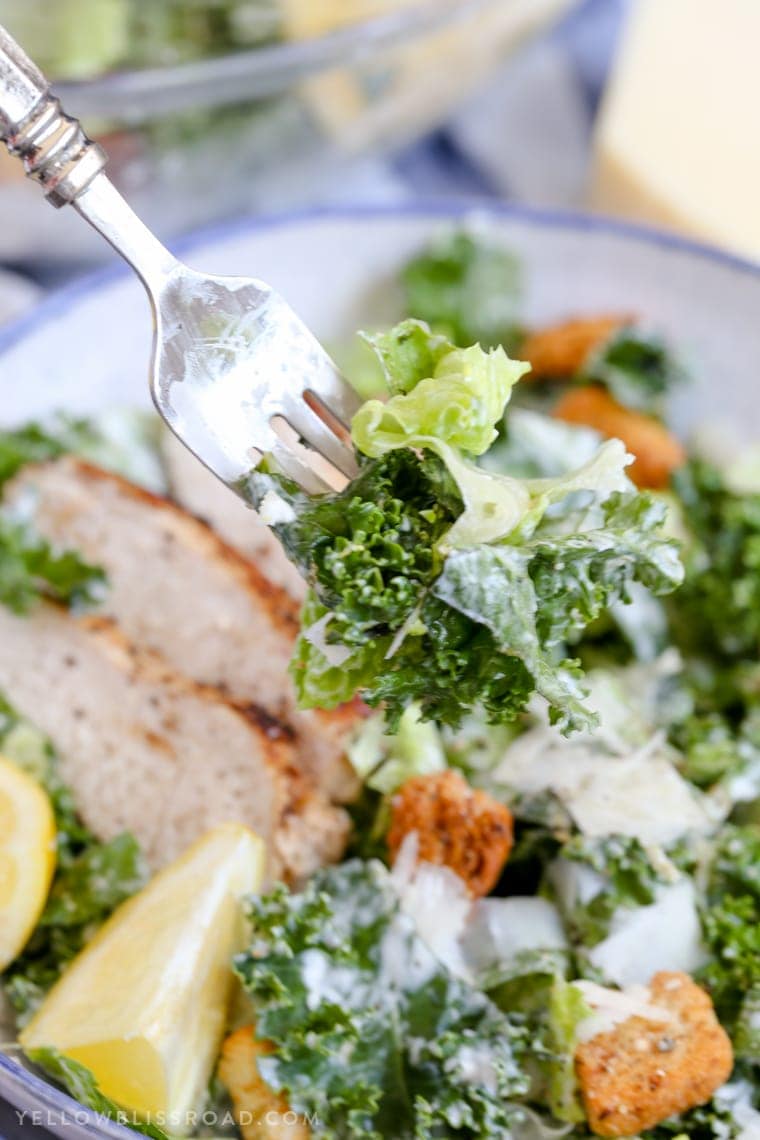 A bite of kale and romaine Caesar salad with lemon