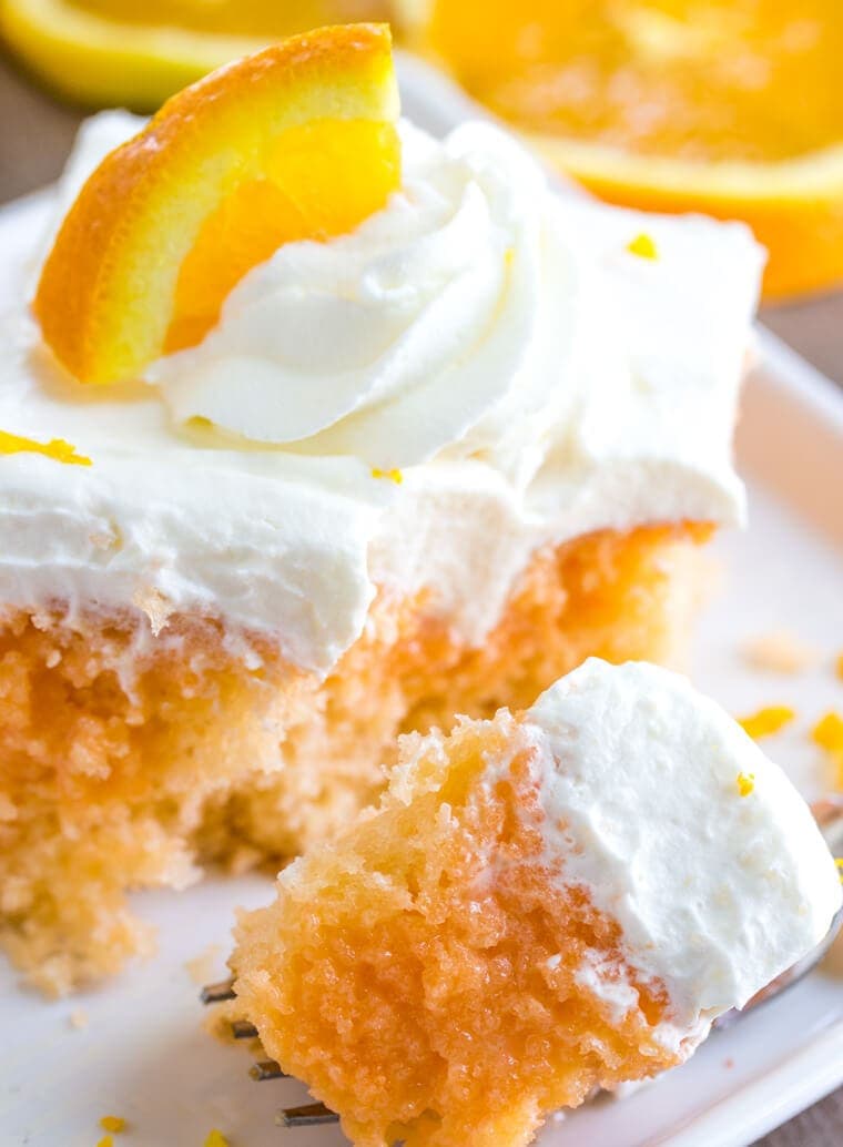 Close up bite of Orange Creamsicle Poke Cake with Whipped Cream Topping Close up bite of Orange Creamsicle Poke Cake with Whipped Cream Topping