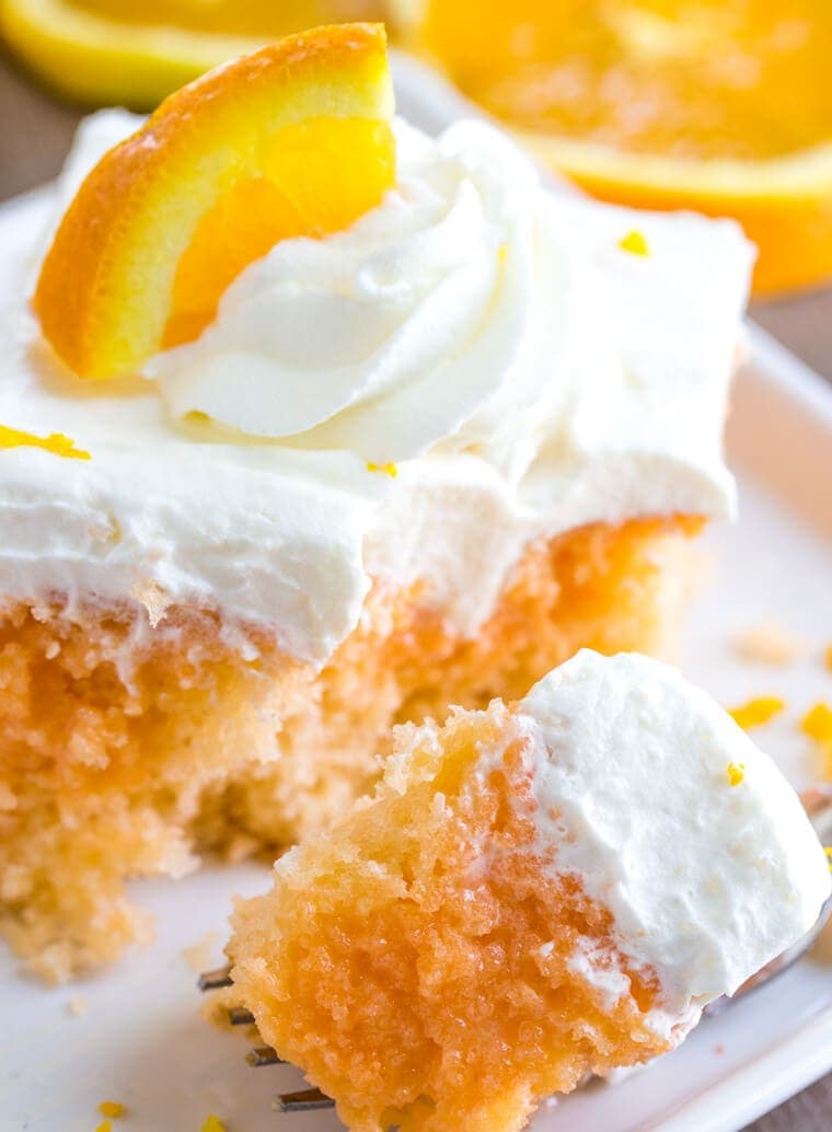 Close up bite of Orange Creamsicle Poke Cake with Whipped Cream Topping 