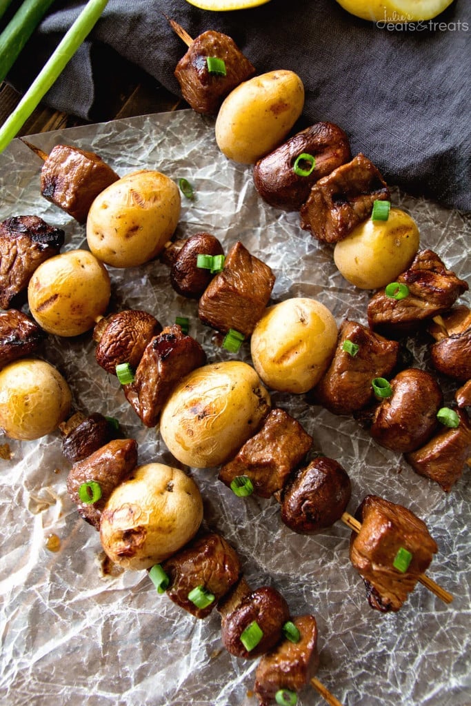 A close up of steak and potato kebabs