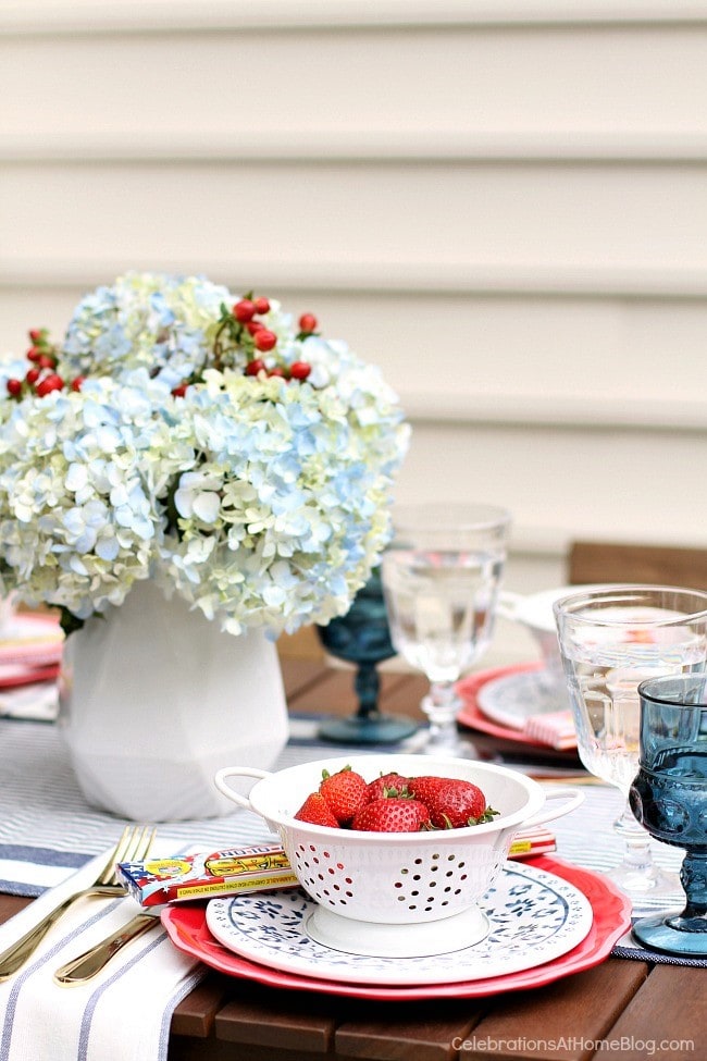 A table topped with a vase of flowers and fourth of July decor