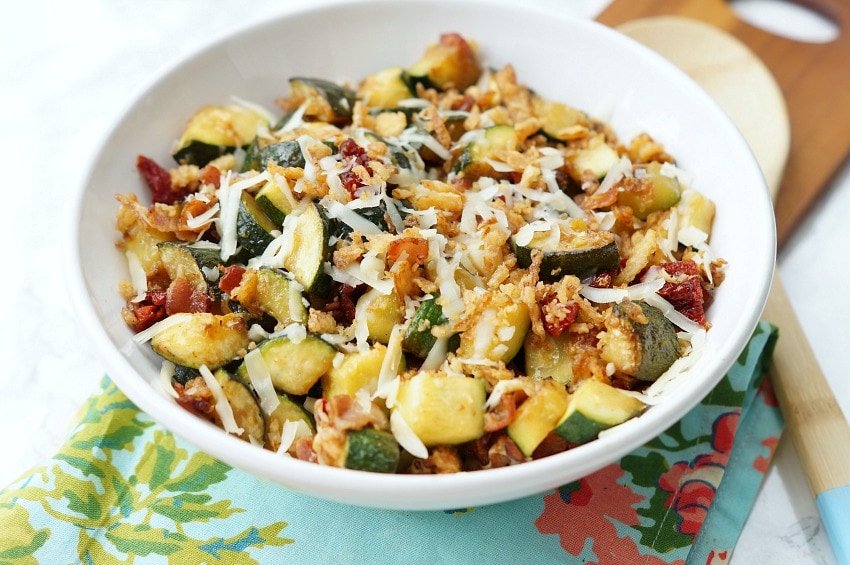 Zucchini with Sun Dried Tomatoes, Bacon, and Crispy Onions is a flavor packed side dish recipe that your family will ask for again and again this zucchini season!