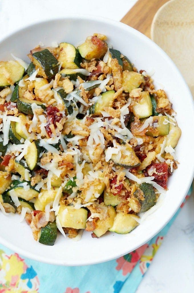 Zucchini with Sun Dried Tomatoes, Bacon, and Crispy Onions is a flavor packed side dish recipe that your family will ask for again and again this zucchini season!