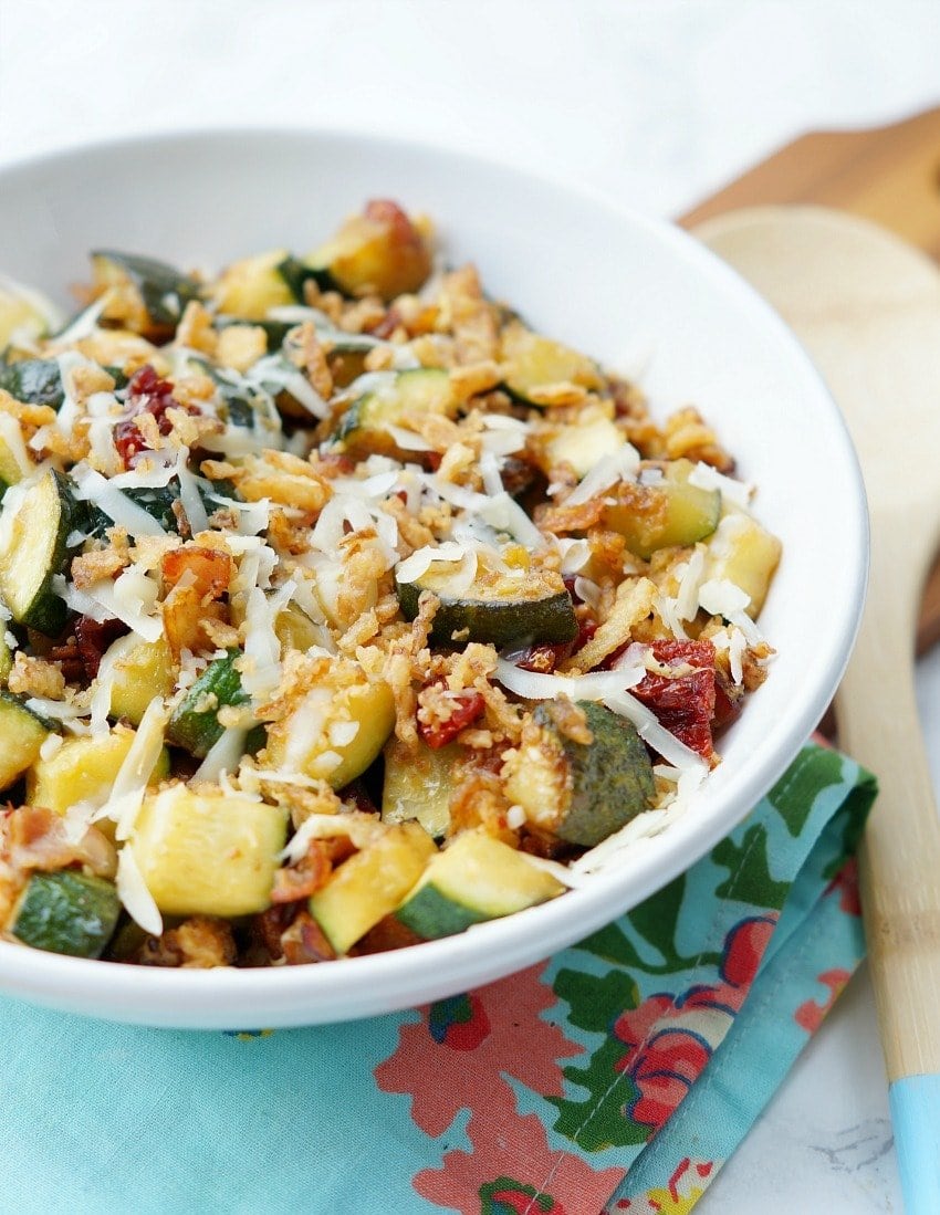 Zucchini with Sun Dried Tomatoes, Bacon, and Crispy Onions is a flavor packed side dish recipe that your family will ask for again and again this zucchini season!