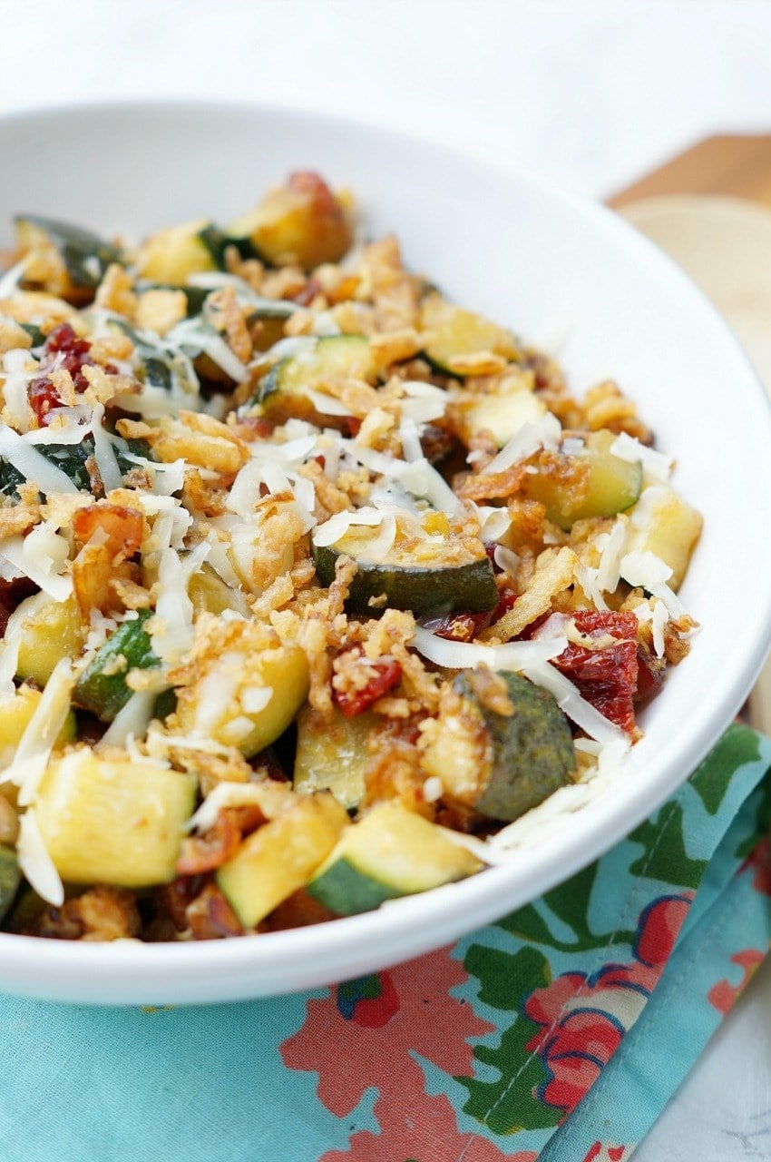 Zucchini with Sun Dried Tomatoes, Bacon, and Crispy Onions is a flavor packed side dish recipe that your family will ask for again and again this zucchini season!