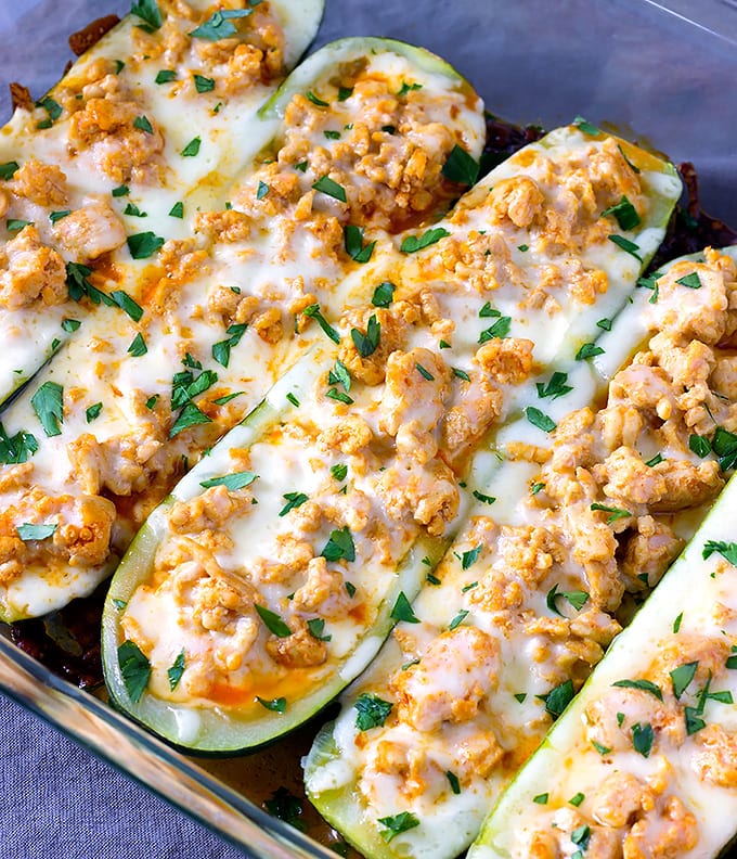 A dish is filled with chicken stuffed zucchini