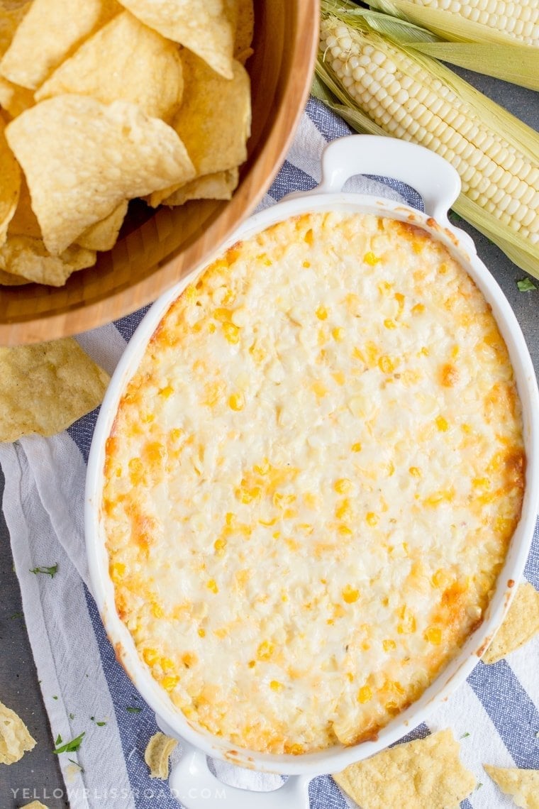 hot corn dip, white baking dish, blue and white towel, chipd