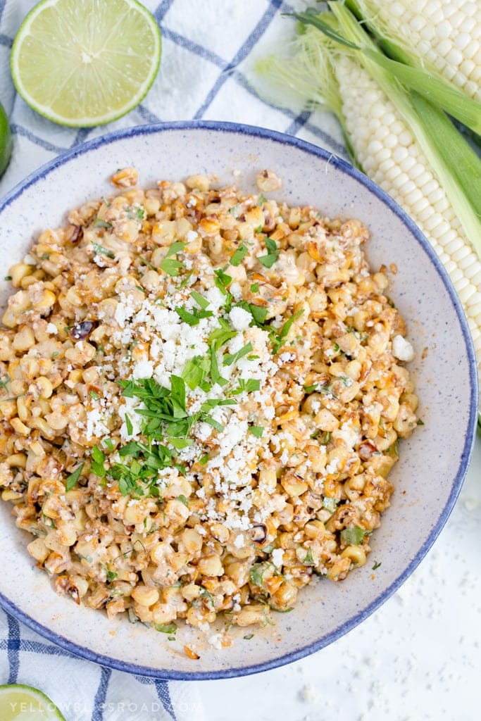 An overhead shot of Mexican Street Corn Salad with ears of corn to the side.