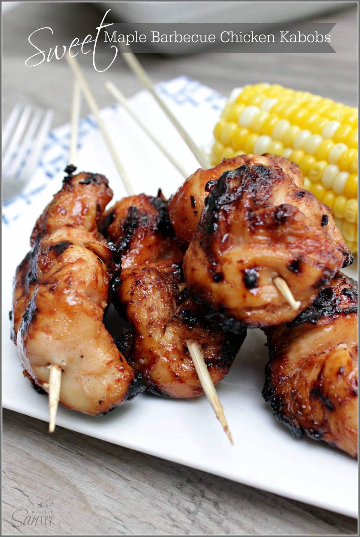 A plate of chicken kabobs and corn