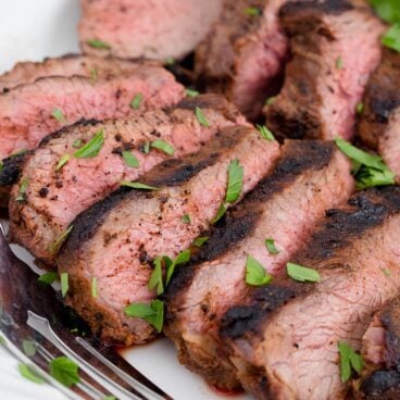 A Tri-tip steak sliced in pieces on a plate