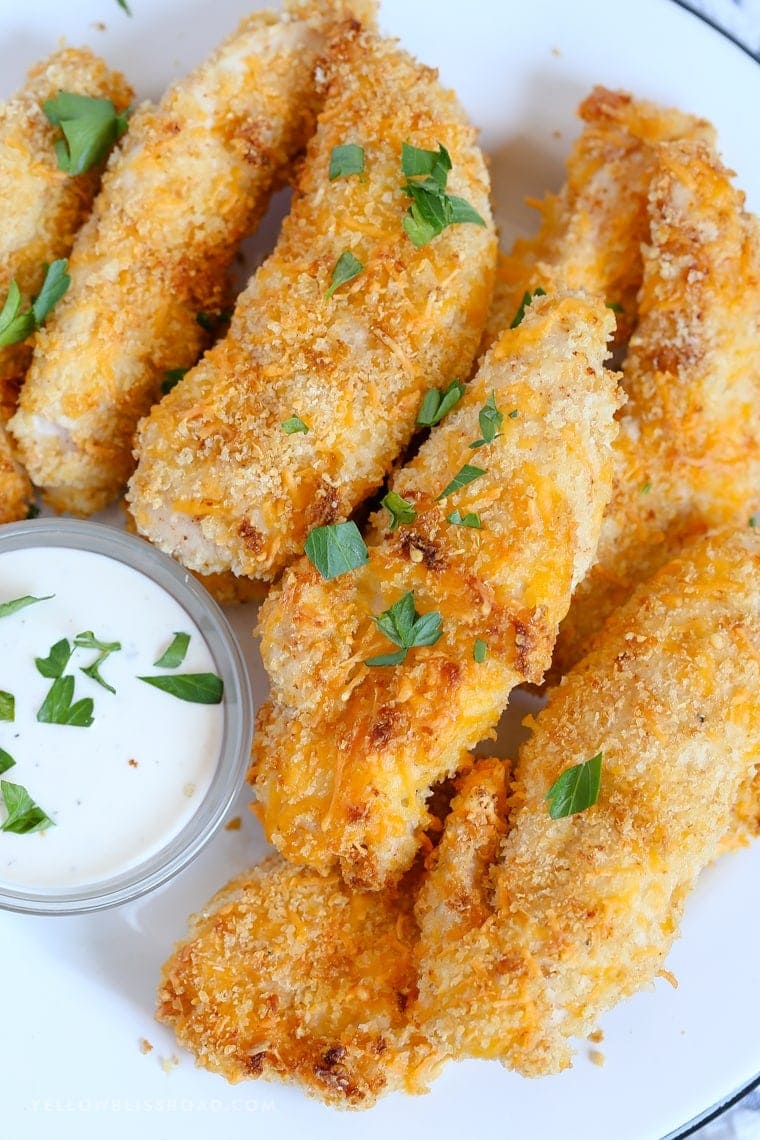 A close up of a platter of crispy baked chicken tenders