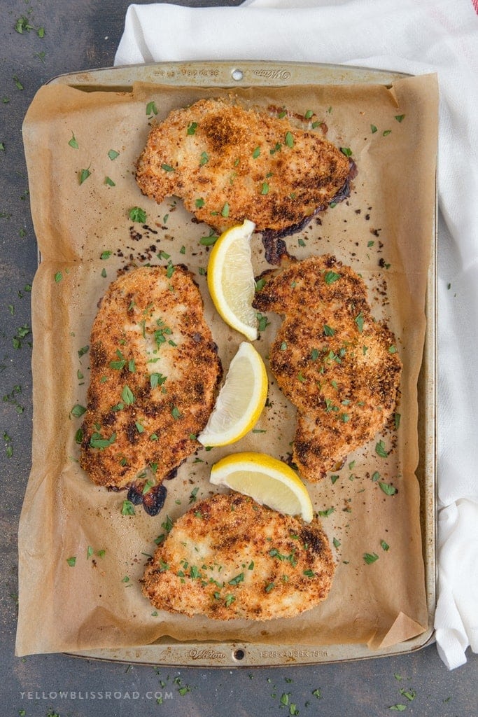 Crispy Garlic Parmesan Baked Chicken laying on parchment paper.